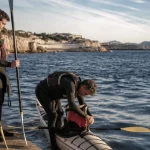 Activités nautiques Marseille : moniteur aide des débutants sur un kayak en eau calme